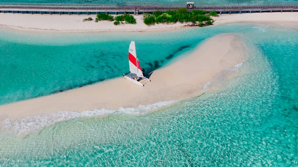 an aerial view of a sailboat on a beach