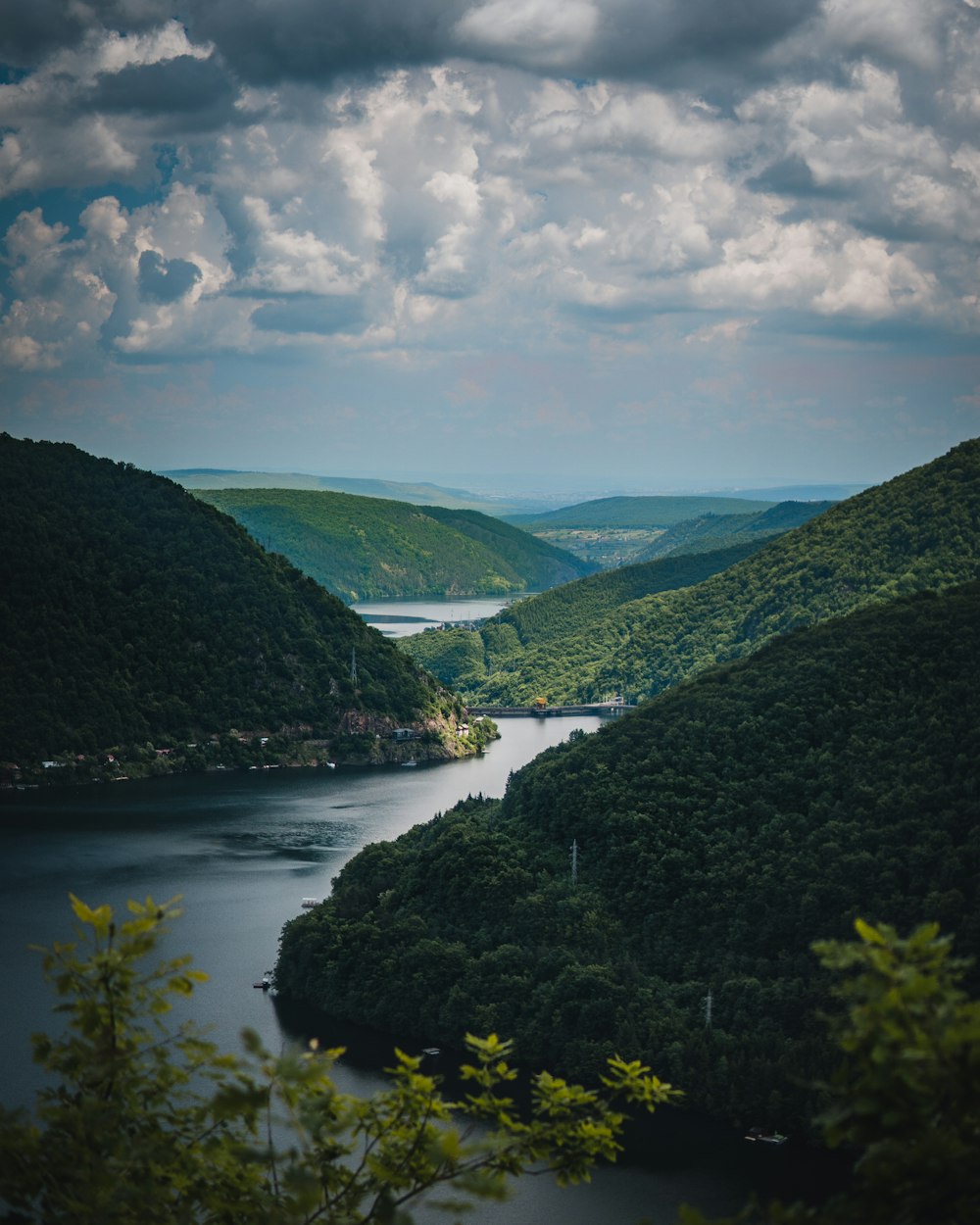 green mountains near river under blue sky during daytime