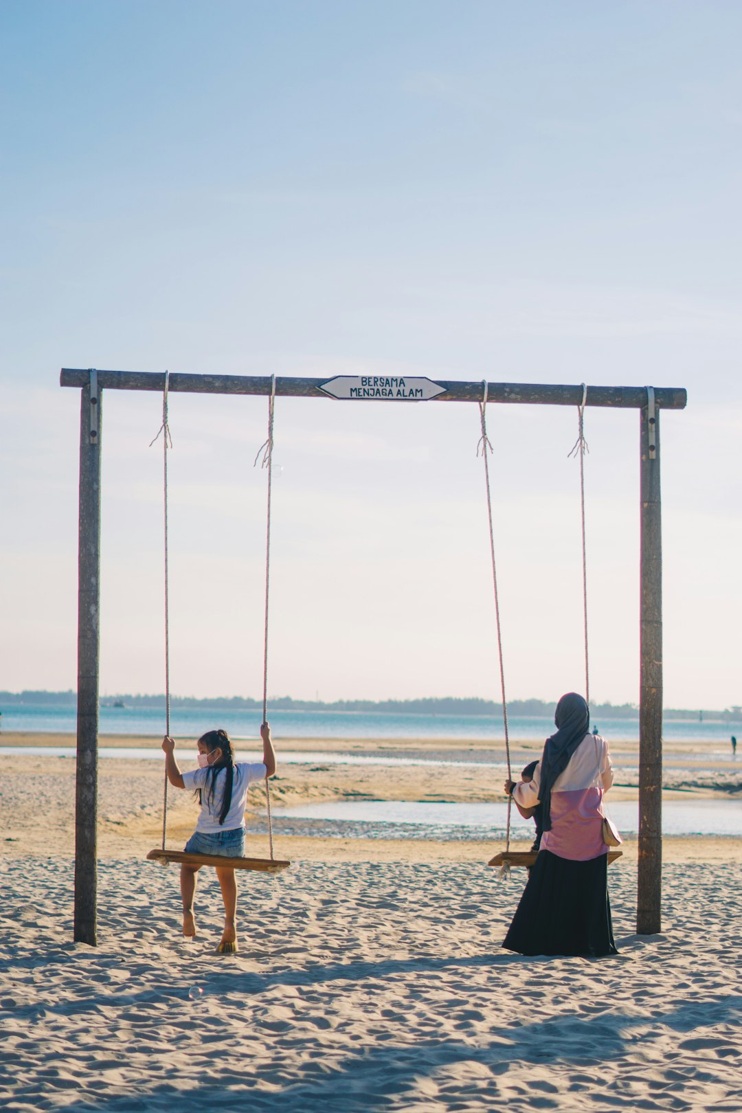 woman in black shirt sitting on swing