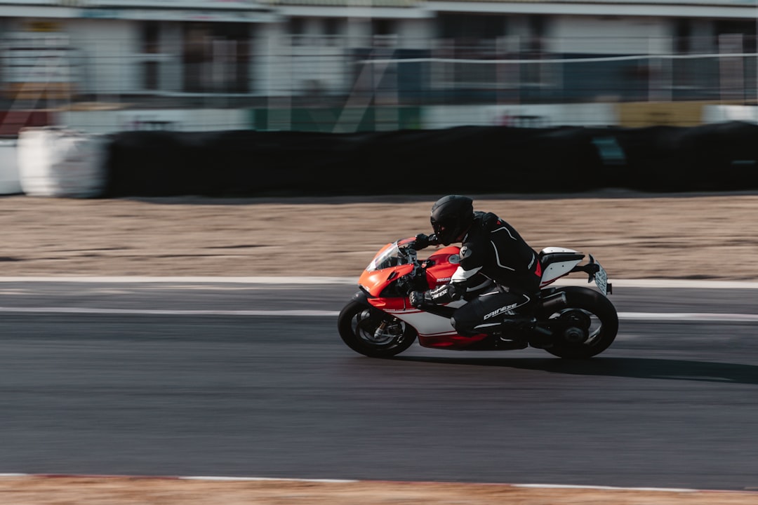 man riding on red and black sports bike on road during daytime