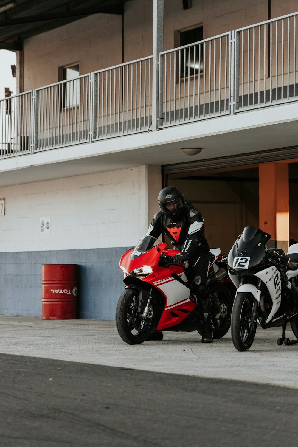 赤と白のスポーツバイクに乗る黒と赤のオートバイヘルメットの男