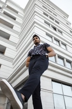 man in blue and white checkered button up shirt and blue denim jeans sitting on white