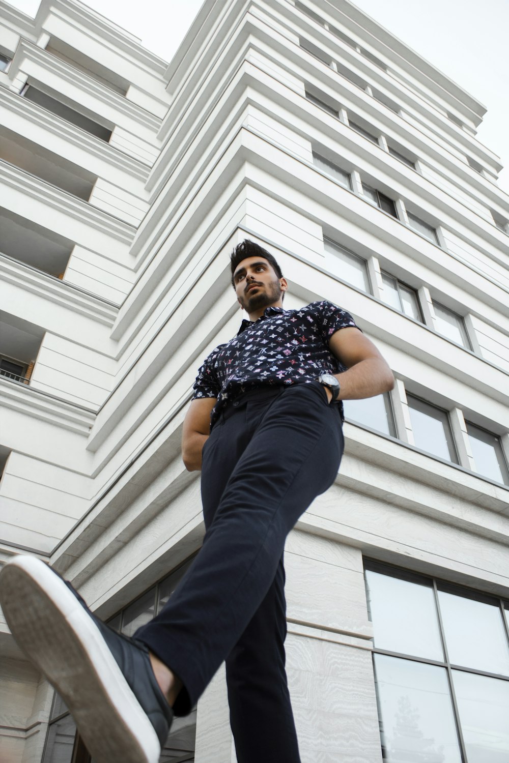 man in blue and white checkered button up shirt and blue denim jeans sitting on white