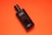 A black bottle of Davidoff Cool Water deodorant rests against a vibrant orange background. The bottle is sleek, with white text labeling it as mild deodorant. The contrast between the dark bottle and the bright background creates a striking visual.