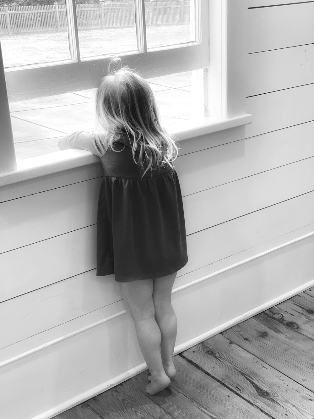 woman in black dress standing on wooden floor