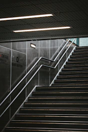 black and white staircase with stainless steel railings