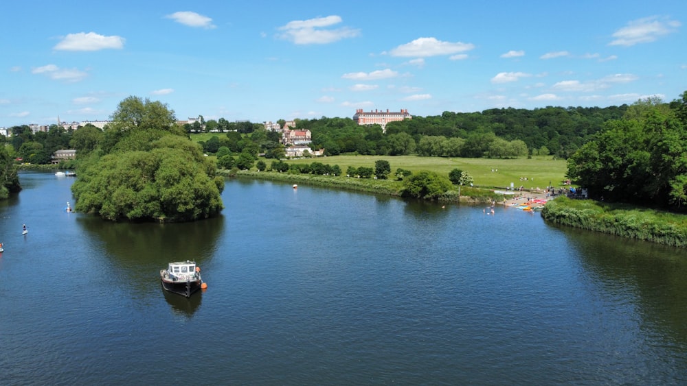 boat on river near green trees during daytime