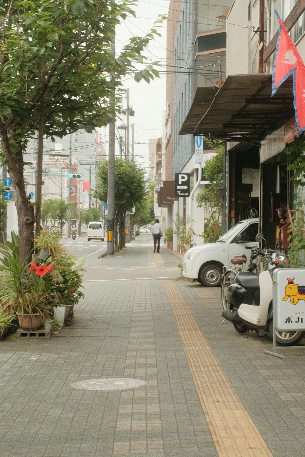 cars parked on sidewalk near buildings during daytime