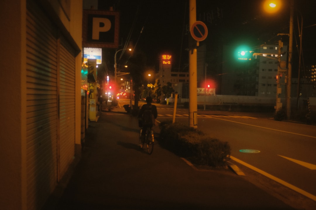 man in black jacket riding bicycle on road during night time