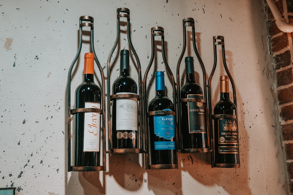six bottles on brown wooden shelf