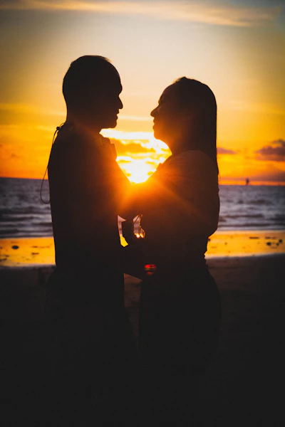 silhouette of man and woman kissing during sunset
