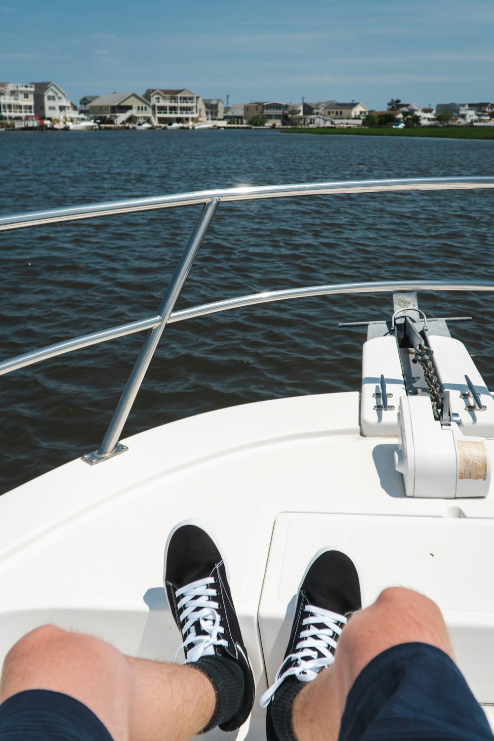 person in black and white sneakers on white boat during daytime