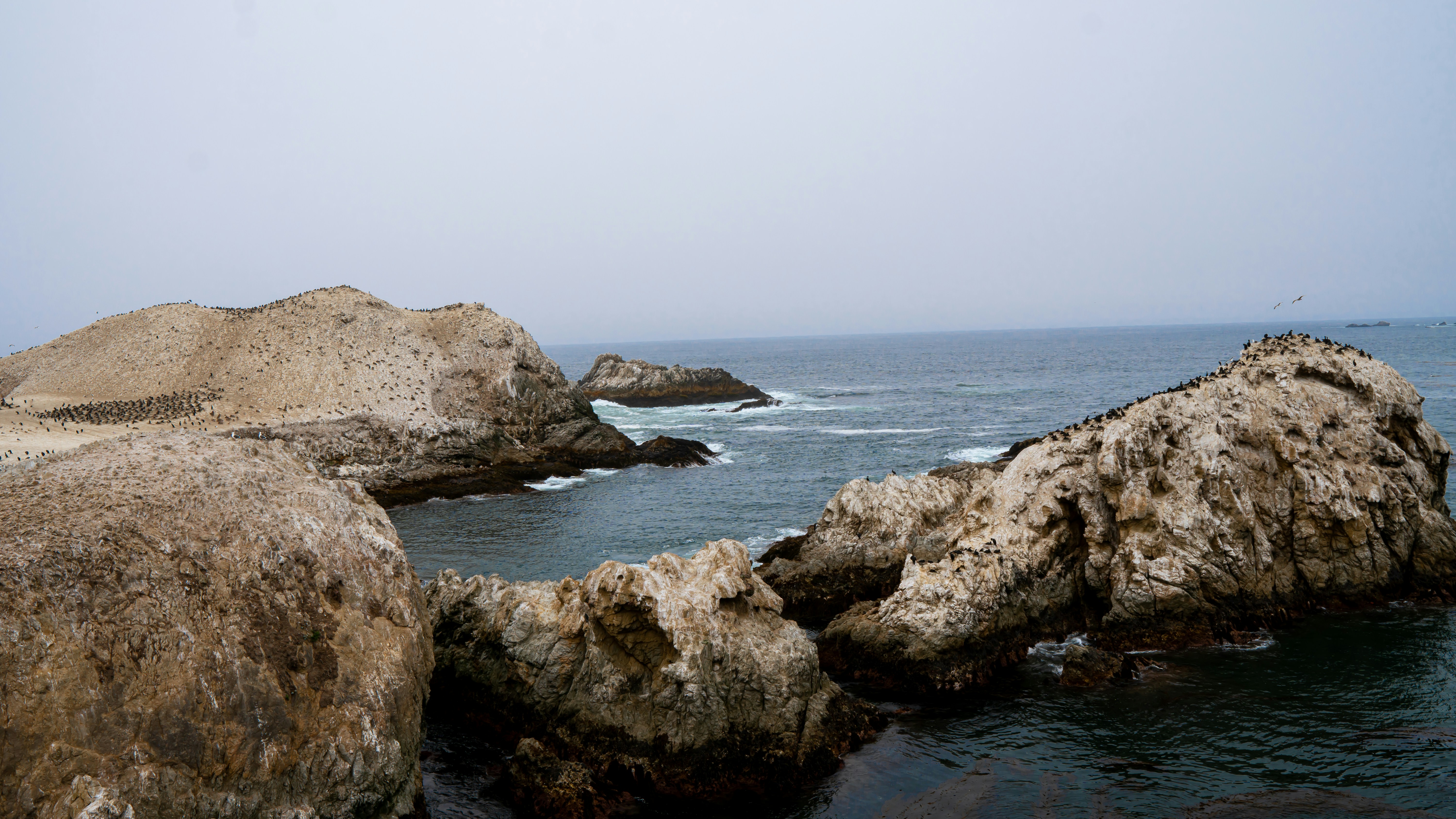 brown rocky mountain beside body of water during daytime