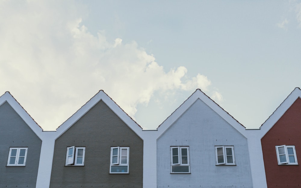 Weißes und graues Haus tagsüber unter weißen Wolken