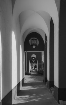 A minimalist, cinematic hallway with charcoal black walls and subtle gold accents.