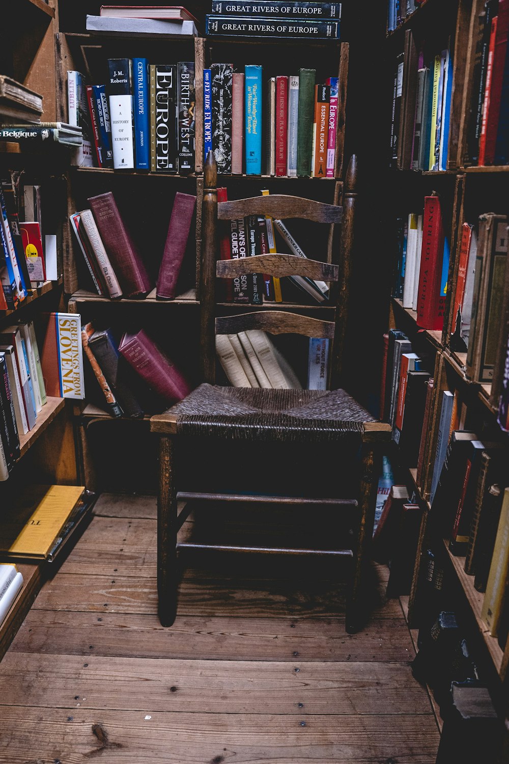 brauner Holzstuhl in der Nähe von Büchern