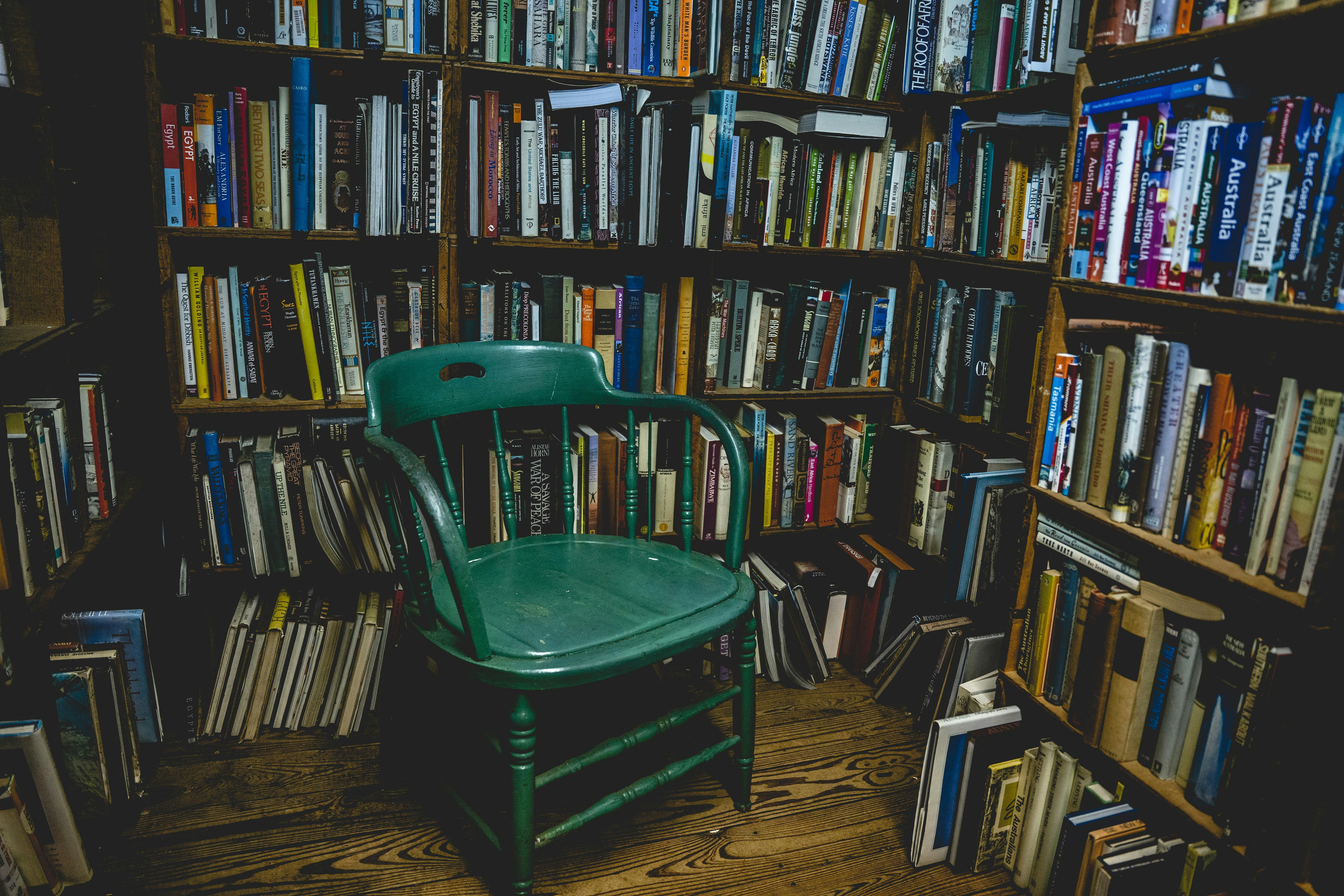 Green plastic chair near brown wooden book shelves photo – Free Lenape