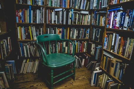 A serene workspace with books, a cozy chair, and a warm ambiance for reflection.