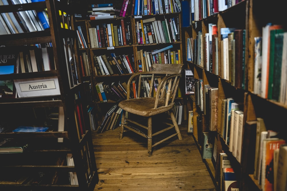 Brauner Holzstuhl in der Nähe von braunen hölzernen Bücherregalen