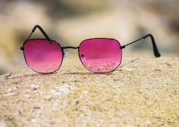 black framed sunglasses on brown sand