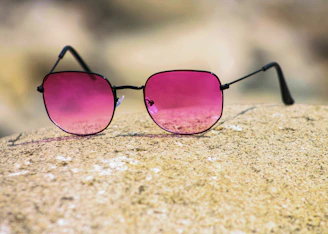 black framed sunglasses on brown sand