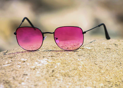 black framed sunglasses on brown sand