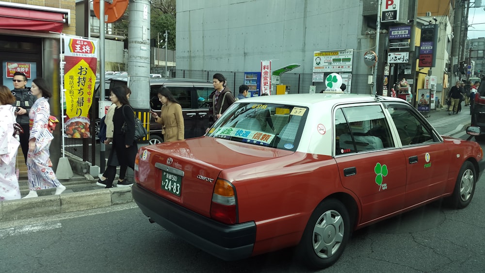 red sedan on the street during daytime