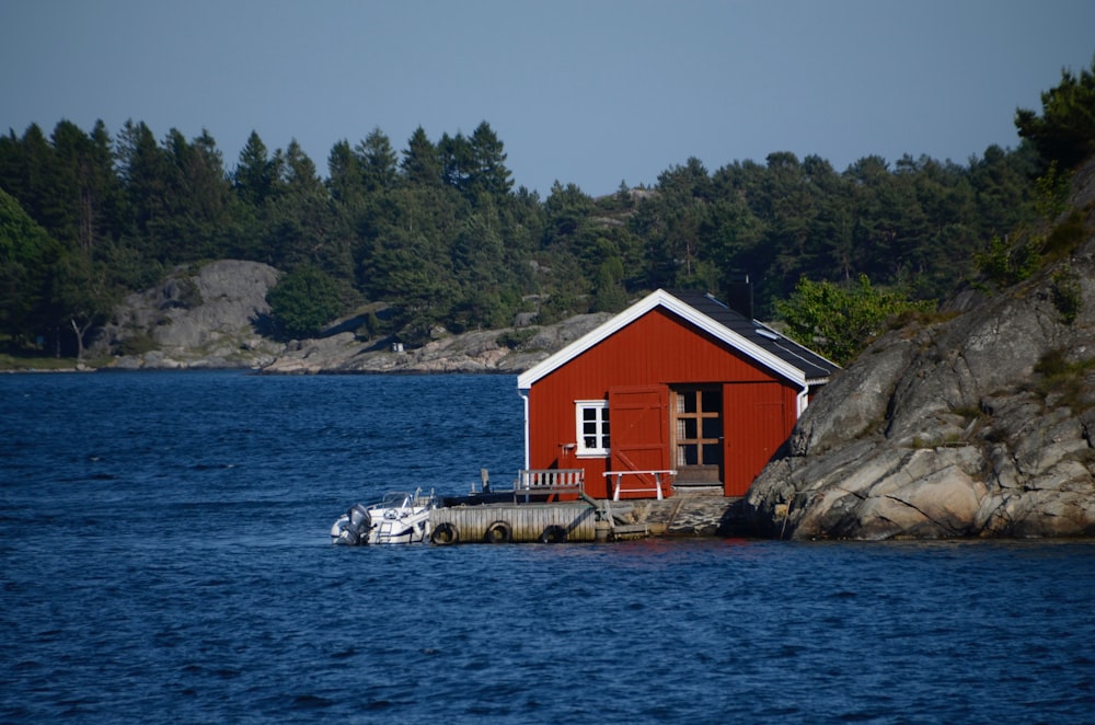 red and white house near body of water during daytime