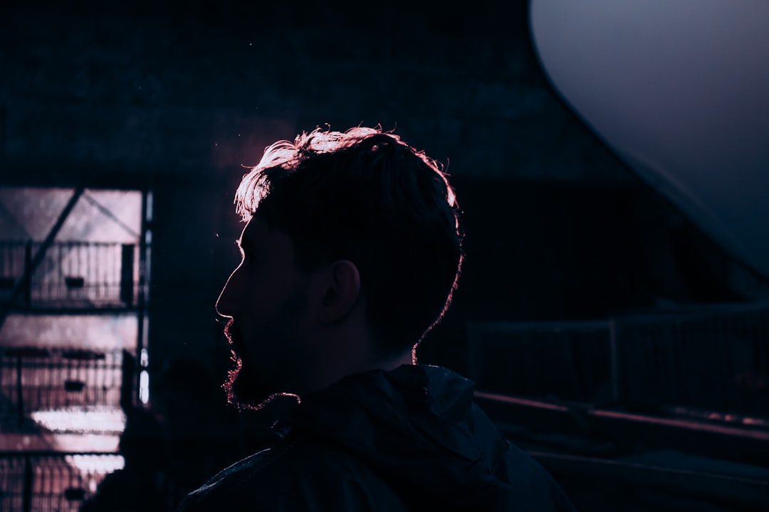 man in black hoodie looking at the window