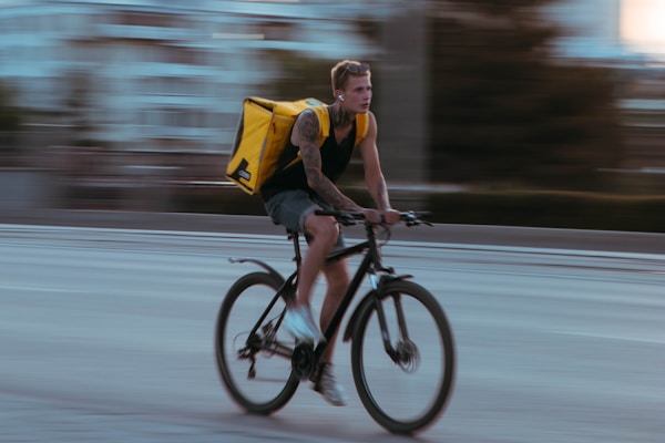 man in yellow shirt riding bicycle on road during daytime