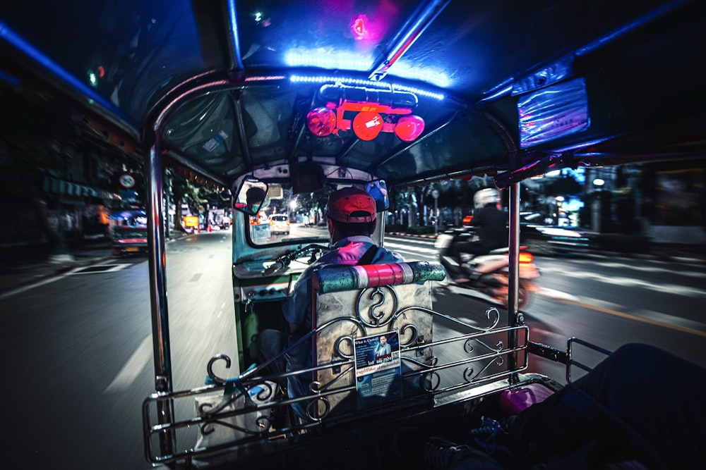 people riding on blue and white car during nighttime