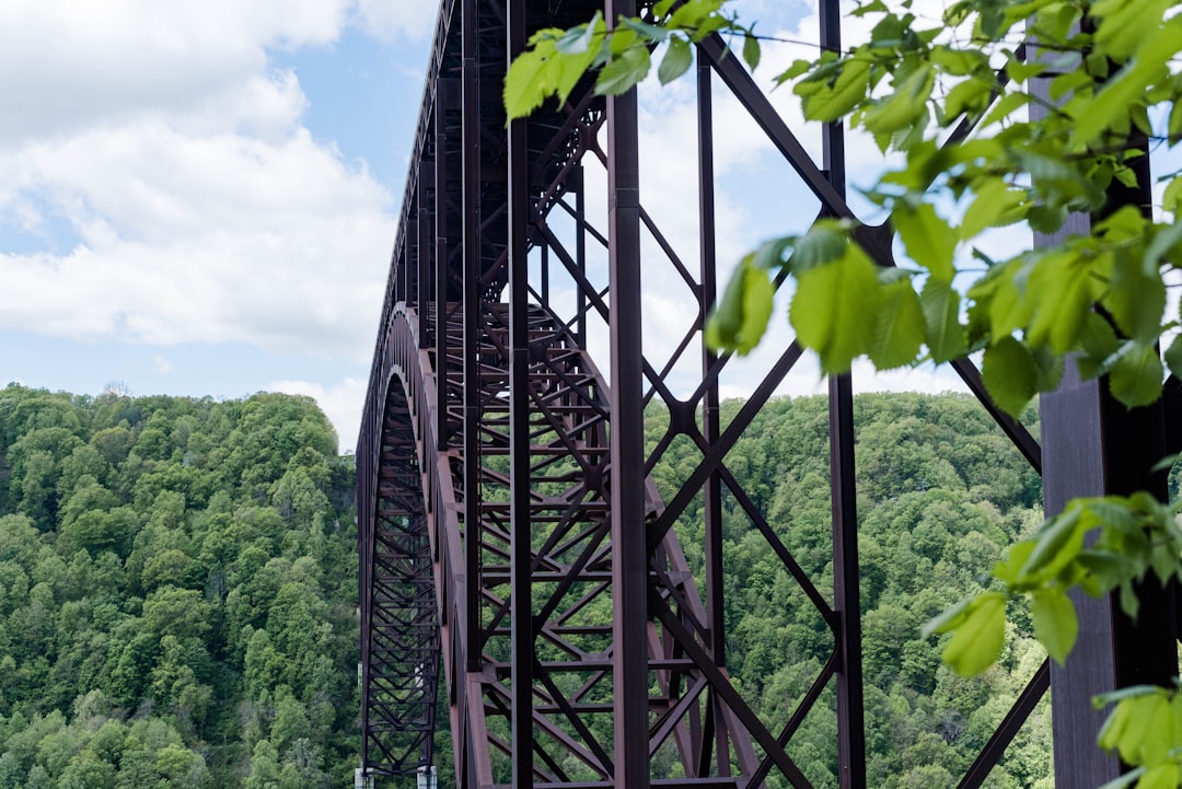 gray metal bridge under white clouds during daytime