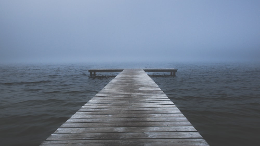 Muelle de madera marrón en el mar durante el día