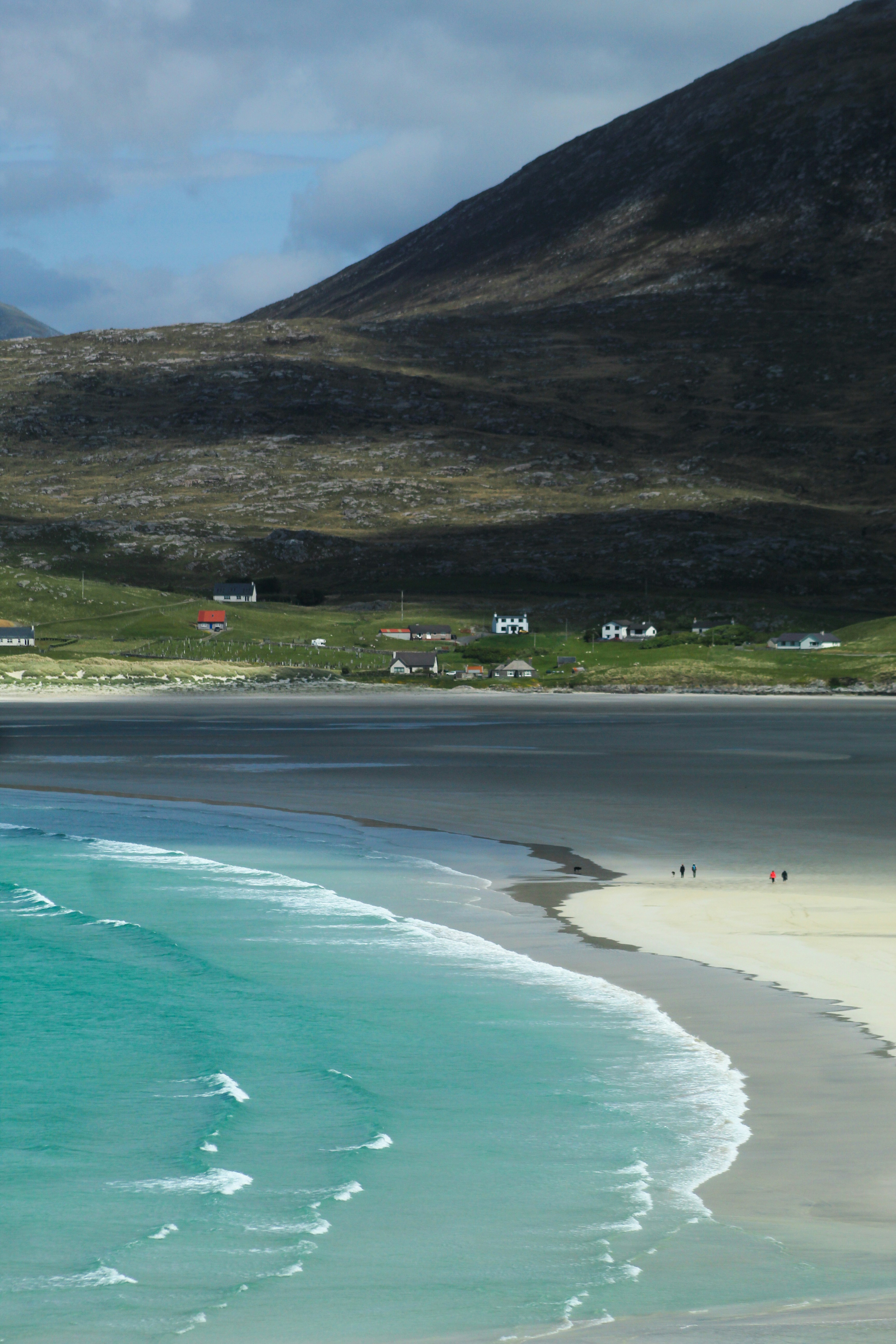 昼間の水域のそばの緑の山