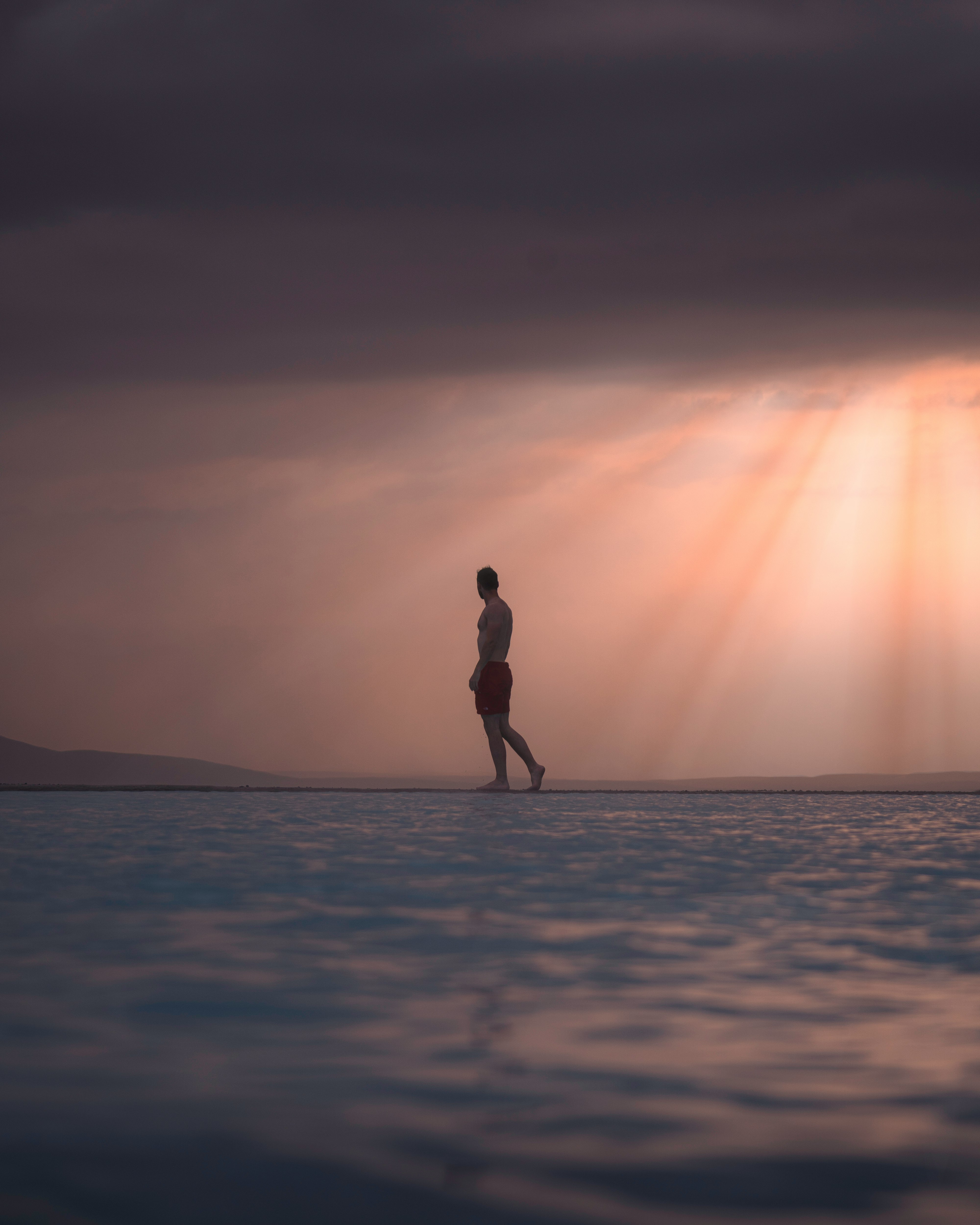 silhouette of woman standing on beach during sunset