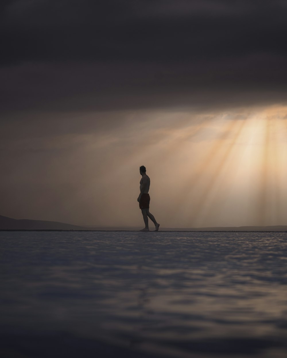 silhouette of woman standing on beach during sunset