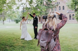 woman in red and black floral dress carrying black leather shoulder bag