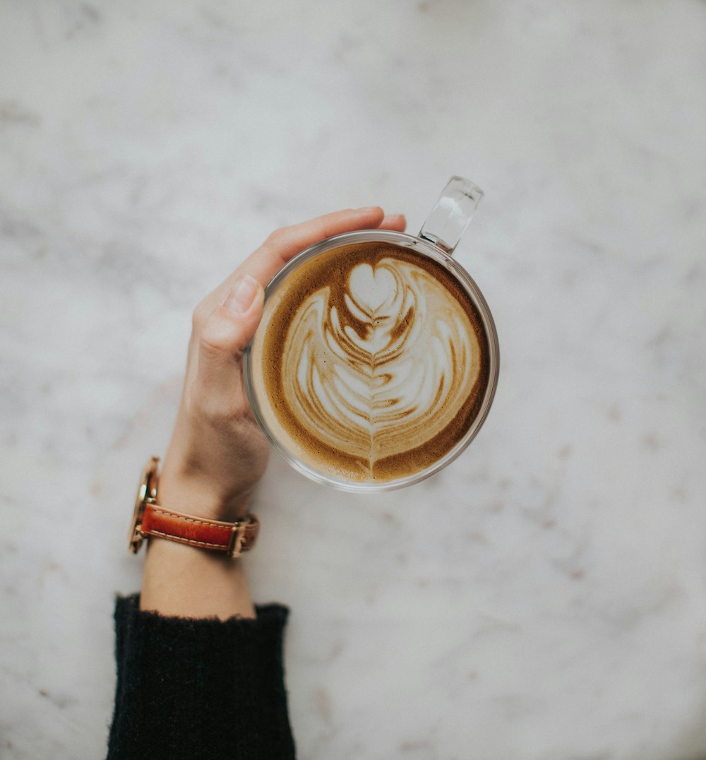 person holding white ceramic mug