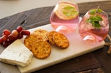 A stylish snack presentation featuring a glass of wine and a small plate of savory treats on a marble table.