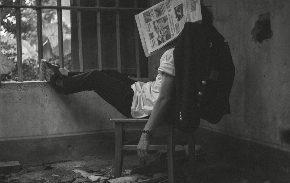 man in black jacket reading newspaper