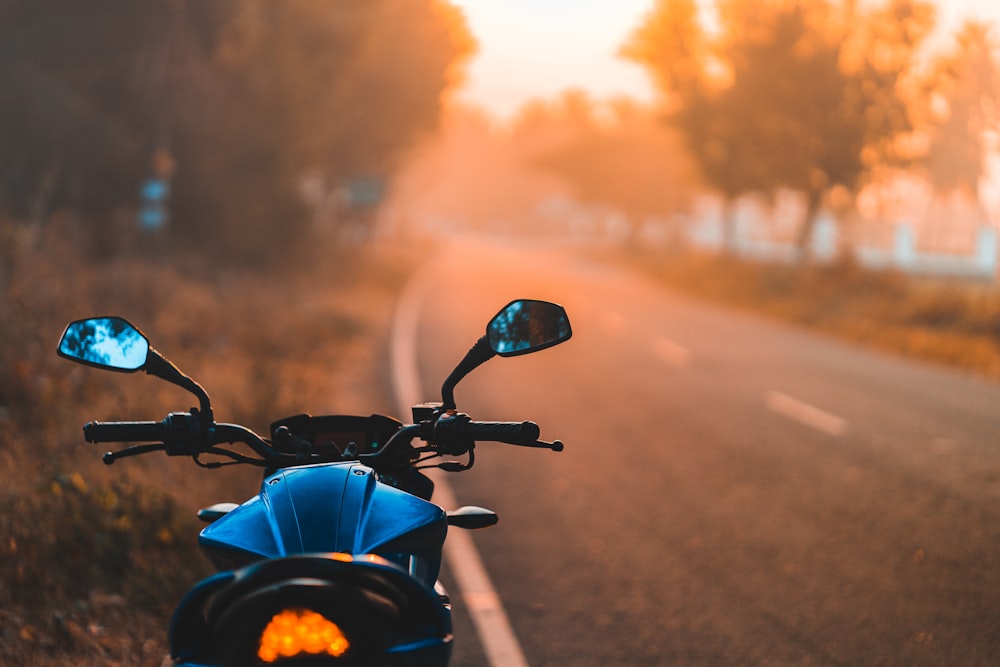 moto noire sur la route au coucher du soleil