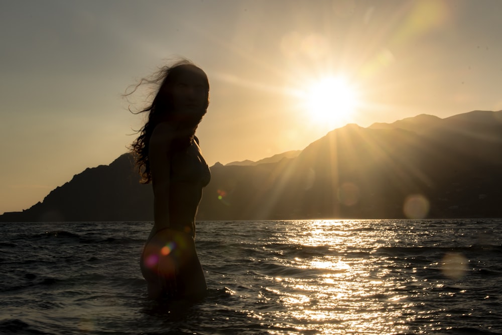 woman in black bikini top standing on water during daytime