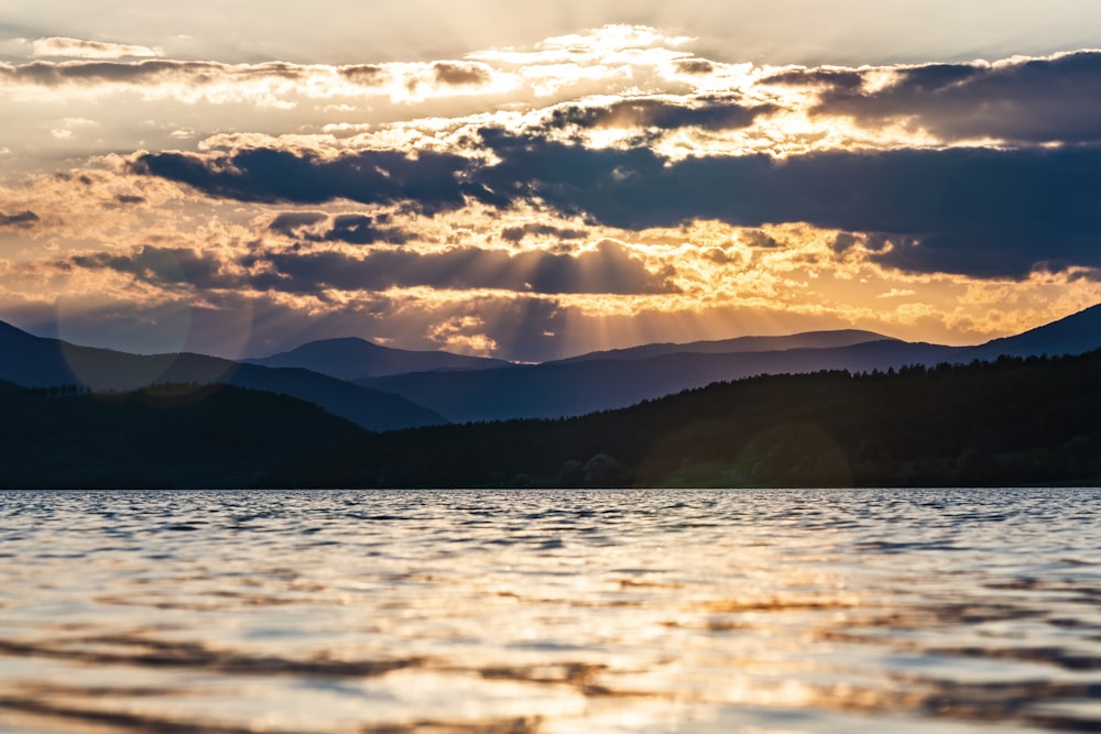 silhouette of mountains under cloudy sky during daytime