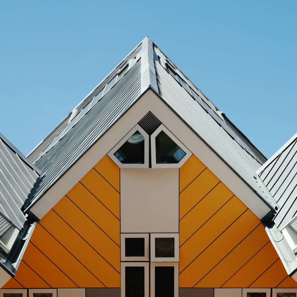 낮에는 푸른 하늘 아래 주황색과 흰색 콘크리트 집
