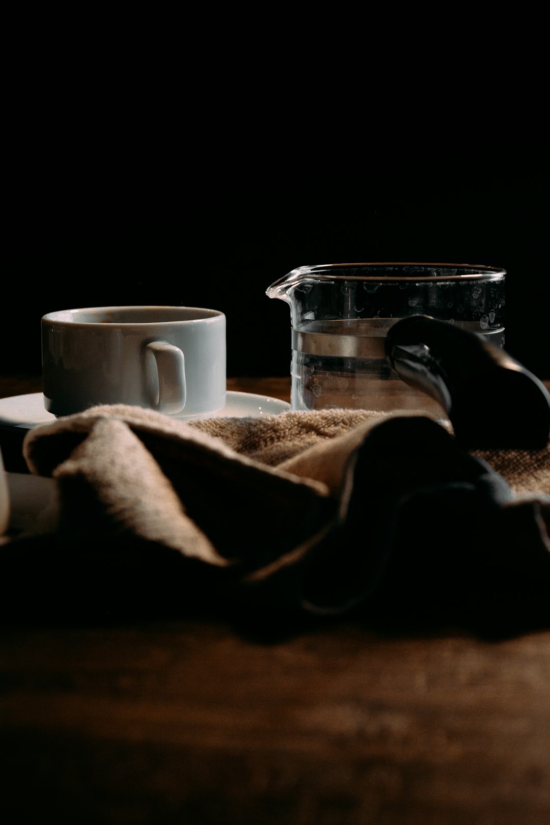 white ceramic mug beside clear glass pitcher