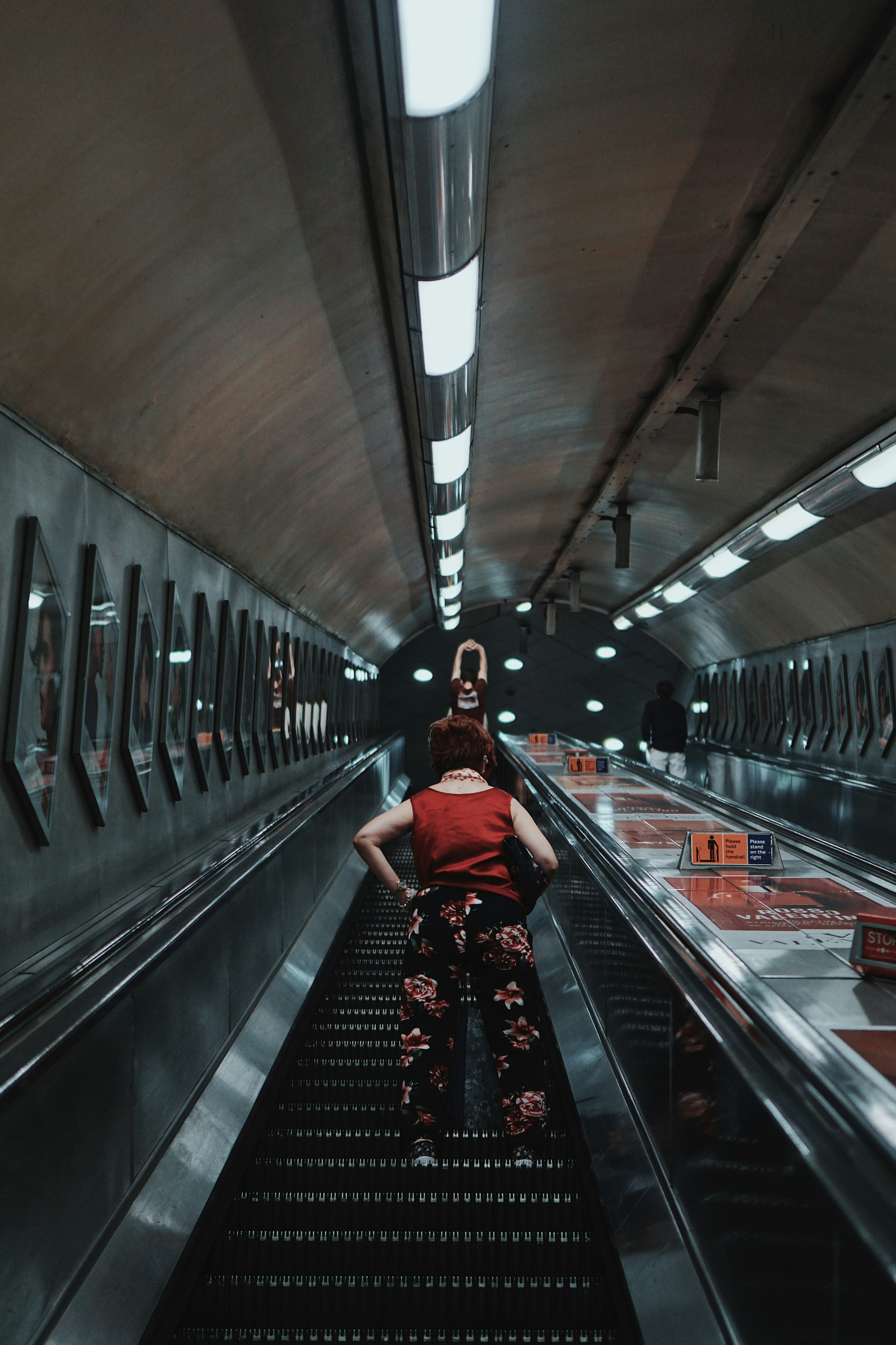 woman in red dress on escalator