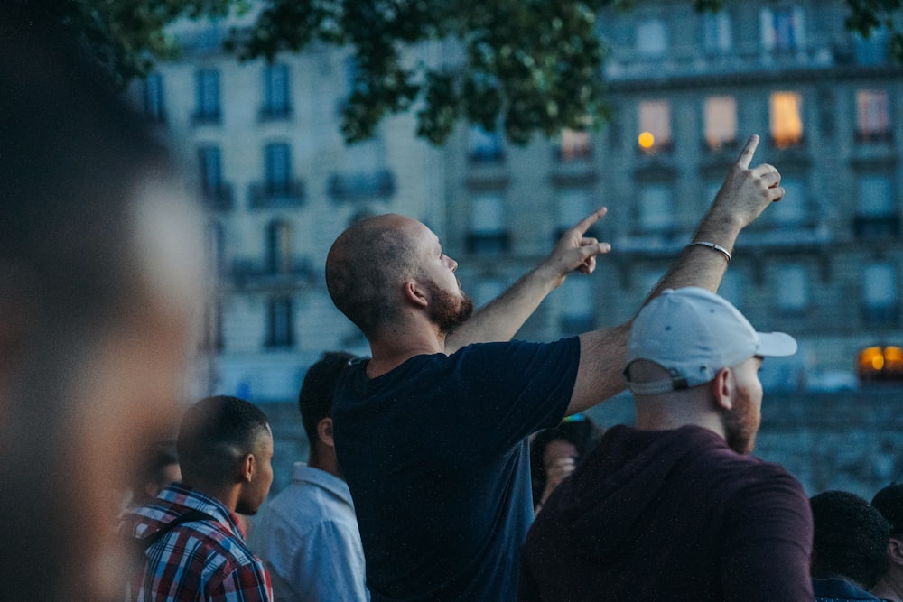 man in black shirt and white cap holding smartphone