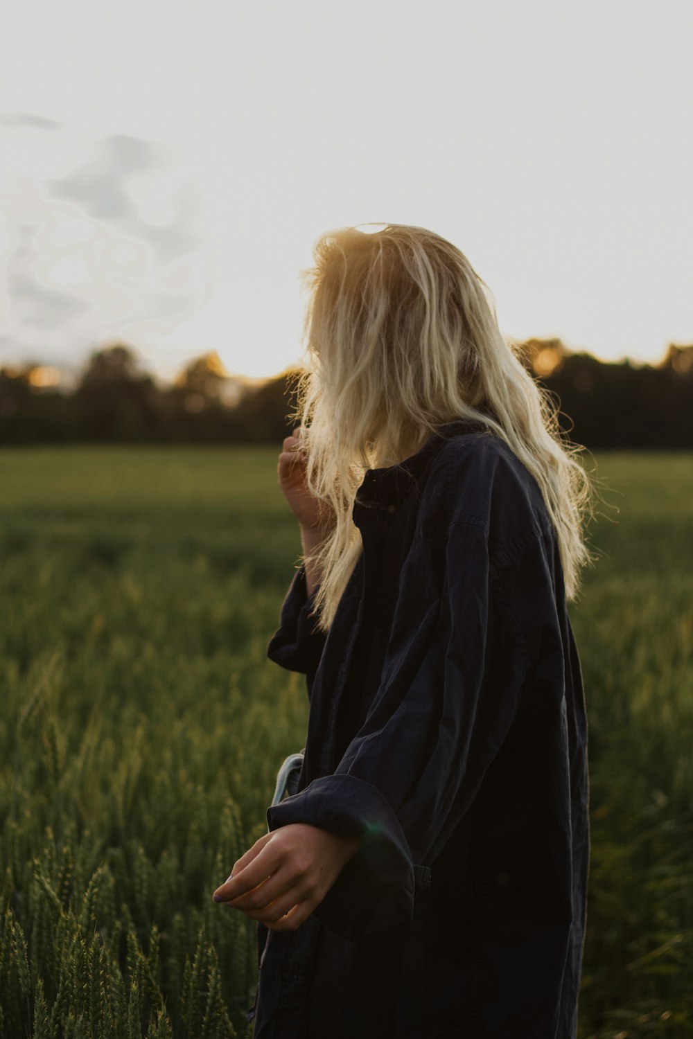 woman in black coat standing on green grass field during daytime