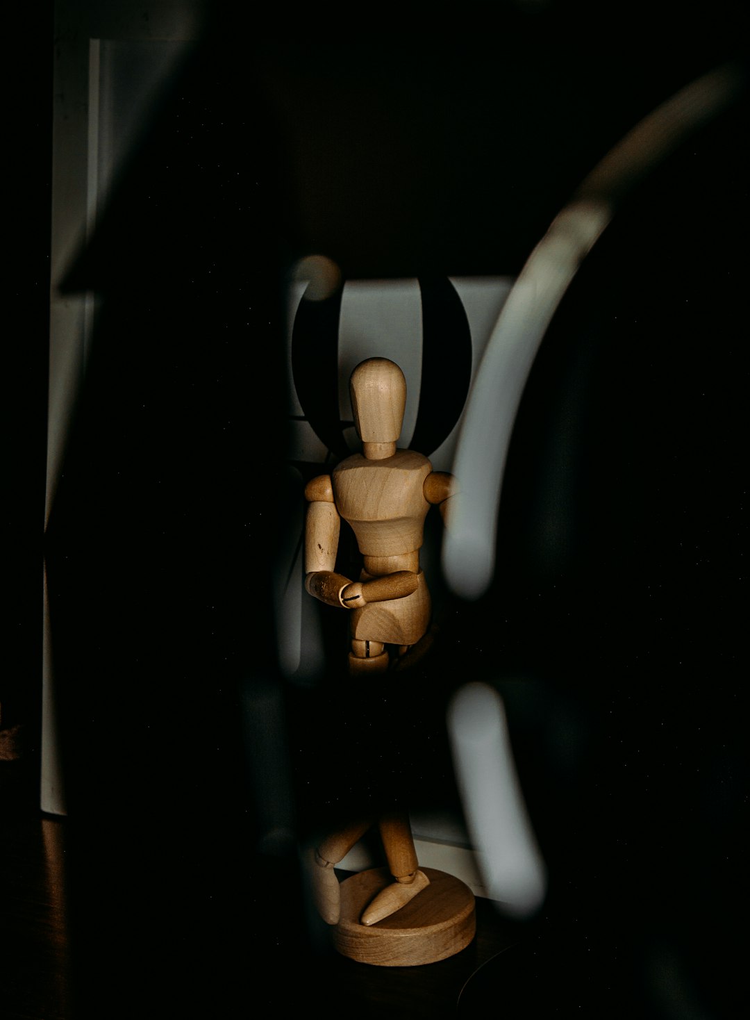 brown wooden human figure on black surface