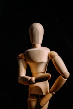 brown wooden human figure on black textile
